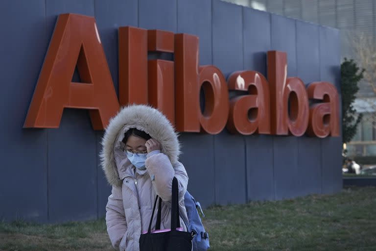 Una mujer camina delante de las oficinas del gigante de comercio en la internet Alibaba en Pekín el 13 de diciembre del 2021. 