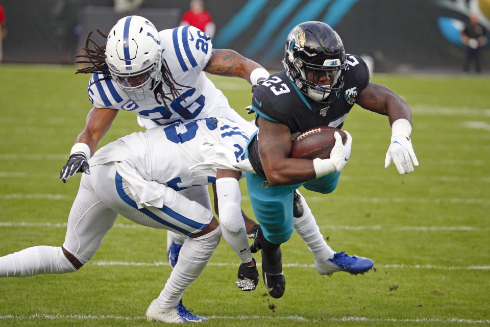 Jacksonville Jaguars running back Ryquell Armstead (23) is stopped by Indianapolis Colts safety Clayton Geathers (26) and cornerback Pierre Desir, lower left, after a run during the first half of an NFL football game, Sunday, Dec. 29, 2019, in Jacksonville, Fla. (AP Photo/Stephen B. Morton)