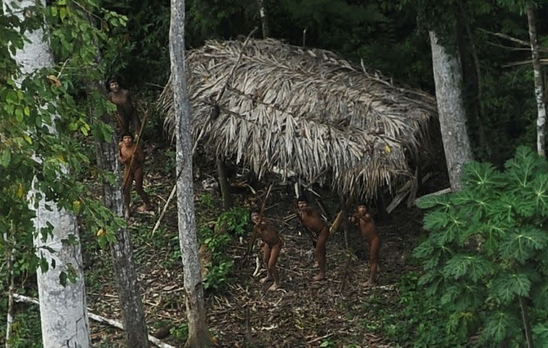 FILE PHOTO: Uncontacted indigenous react to a plane flying over their community in the Amazon basin