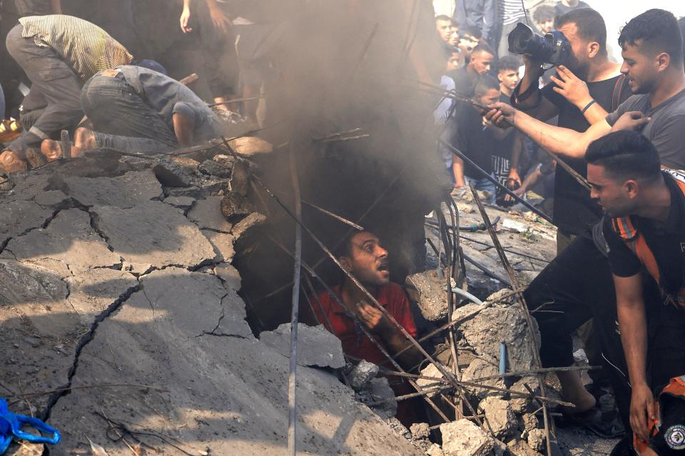 People look for survivors amid the rubble of a building destroyed by an Israeli airstrike in Khan Younis, Gaza, on Monday. 