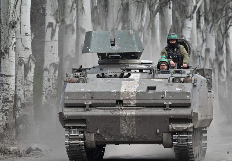 Militares ucranianos montan en un vehículo blindado de transporte de tropas (APC) YPR-765 en una carretera cerca de Bakhmut, región de Donetsk, el 11 de abril de 2023, en medio de la invasión rusa de Ucrania. 