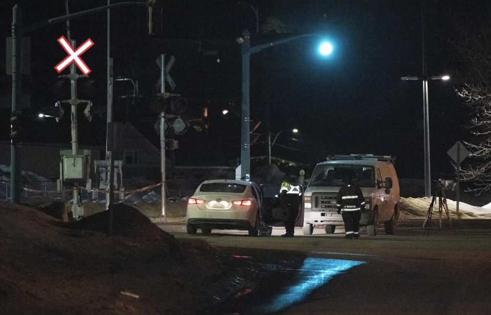 Police officers tour the perimeter of a fatal accident, in Amqui, Quebec, Monday, March 13, 2023. Two men died after a pickup truck plowed into pedestrians beside a road, although a senior Canadian official rapidly ruled out a terrorism attack or a national security incident. (Jacques Boissinot/The Canadian Press via AP)