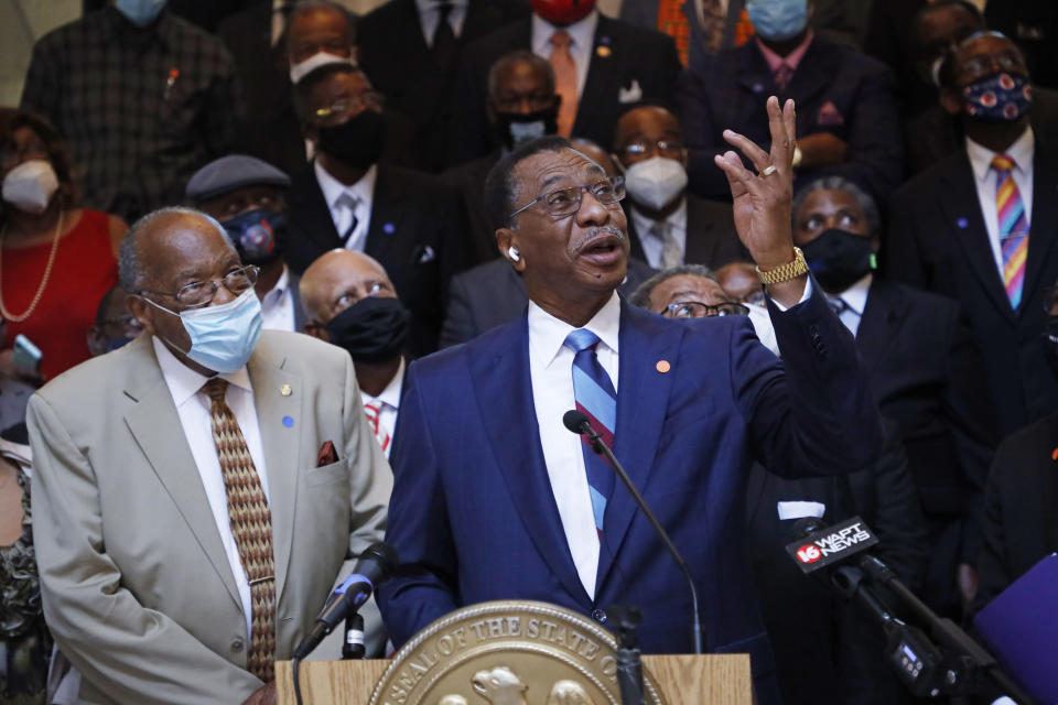 Rep. Ed Blackmon, D-Canton, points to a Mississippi state flag on an upper floor of the Capitol and calls for it to be brought down and replaced, Thursday, June 25, 2020, during a news conference with a large number of Black pastors at the Capitol in Jackson, Miss. The current flag has in the canton portion of the banner the design of the Civil War-era Confederate battle flag, that has been the center of a long-simmering debate about its removal or replacement. (AP Photo/Rogelio V. Solis)