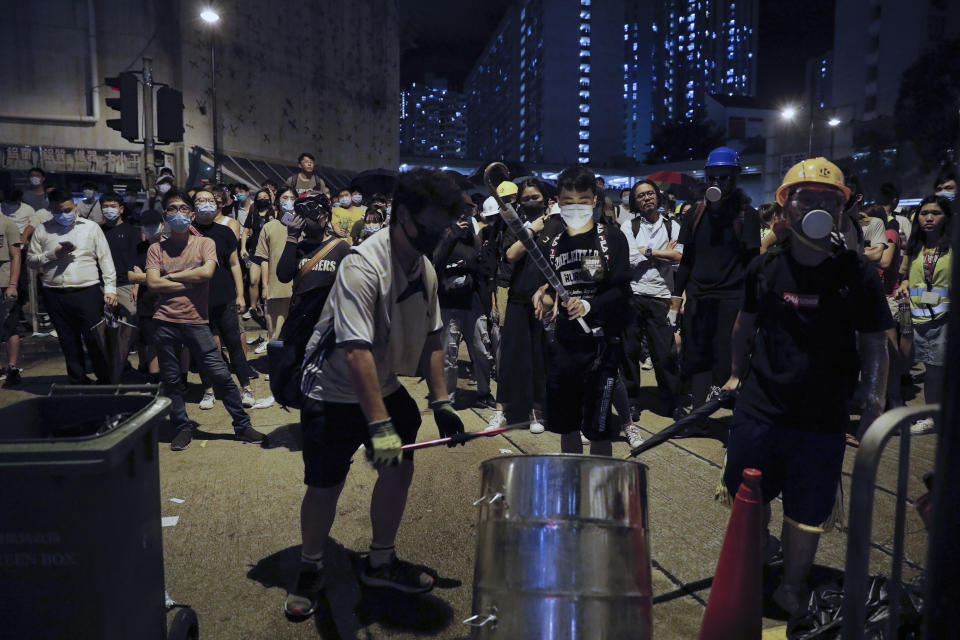 Protesters hit a drum to make noise to policemen as they stage a protest outside Kwai Chung police station in Hong Kong, Wednesday, July 31, 2019. Protesters clashed with police again in Hong Kong on Tuesday night after reports that some of their detained colleagues would be charged with the relatively serious charge of rioting. (AP Photo/Vincent Yu)