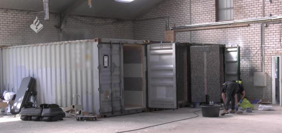 Picture of shipping containers lying with their doors open in an otherwise deserted warehouse