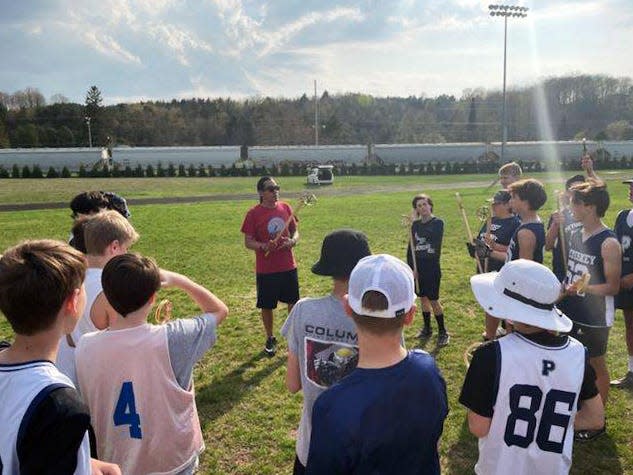 R.J. Smith of Lac Courte Oreilles Ojibwe (Wis.) speaks with Petoskey Middle School lacrosse players at the old Curtis Field site.