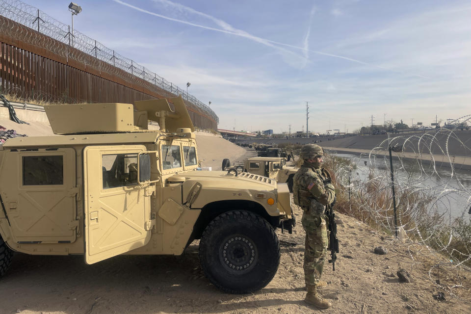 Troops stand guard the along the U.S.-Mexico border in El Paso, Texas, on Tuesday, Dec. 20, 2022. (AP Photo/Giovanna Dell'Orto)