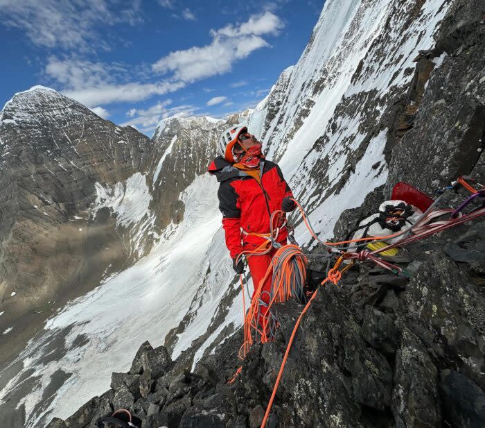 Climber with rope coils looks up