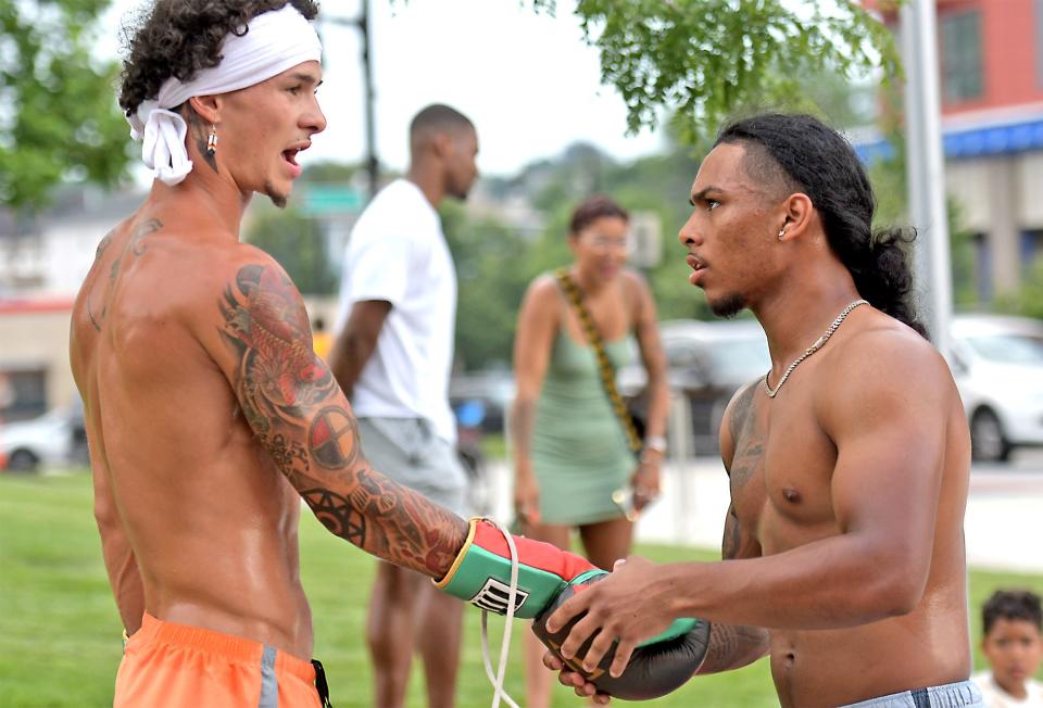 Rob Degaetano of Douglas, left, a member of the Wampanoag Tribe, gets a hand putting on his gloves from Keno Luna of Worcester, as he prepares to work out in front of Polar Park to promote the Punch-Out at Polar Park card on Aug. 4.