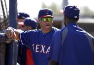 Seattle Seahawks quarterback Russell Wilson, left, talks with Jurickson Profar, right, as the Texas Rangers takes batting practice during spring training baseball practice, Monday, March 3, 2014, in Surprise, Ariz. (AP Photo/Tony Gutierrez)