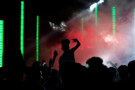 Young people dance and cheer as they attend electronic music concert with western tunes at closed Hall in Shaab Stadium for the first time in Baghdad