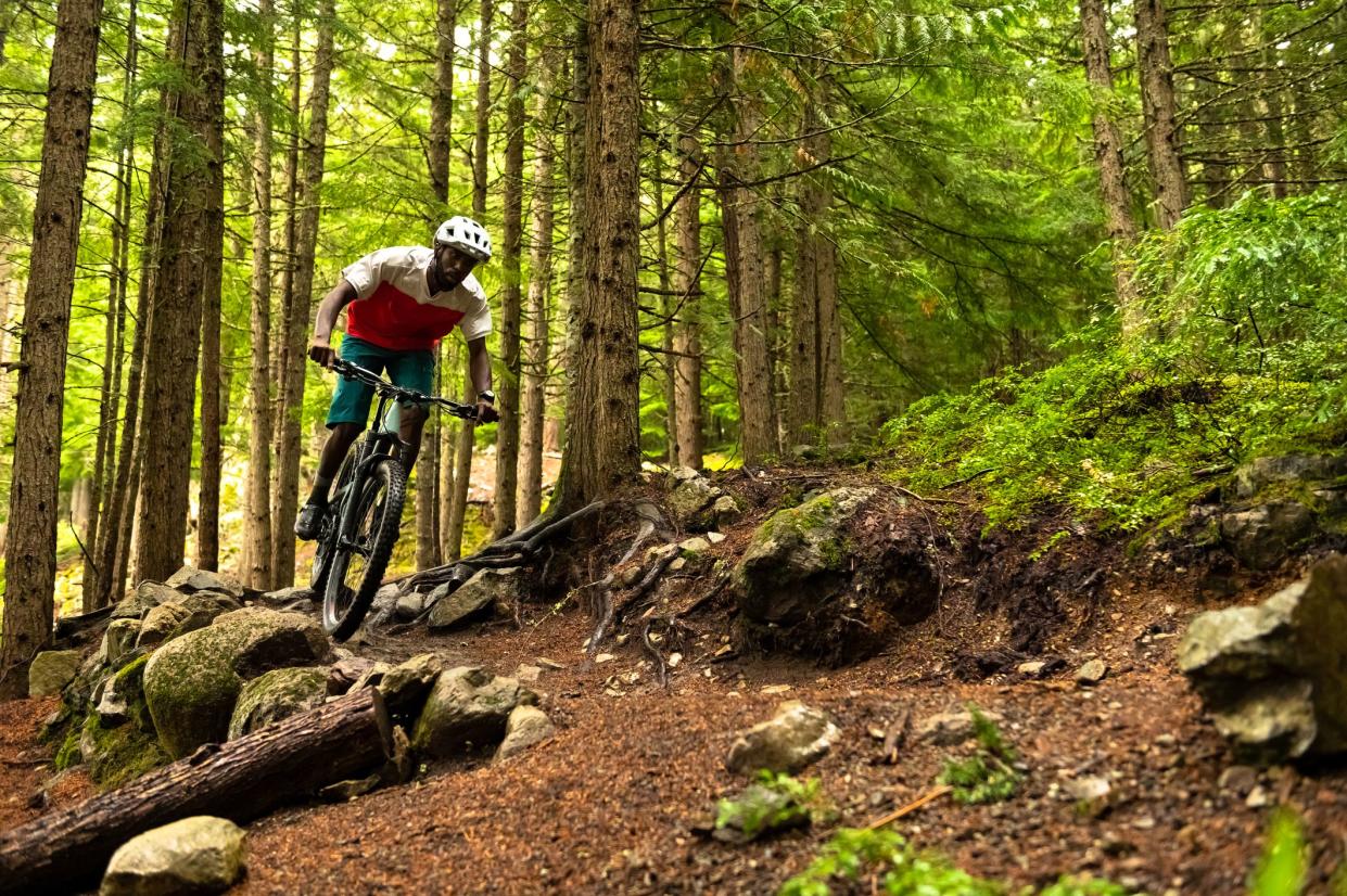 African American athlete riding a mountain bike. Best biking destinations in North America. Living an active lifestyle.