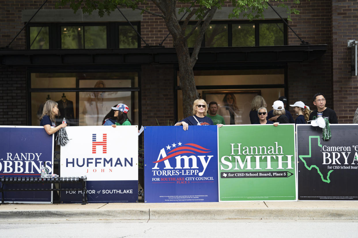 People hold campaign posters for various candidates in municipal elections in Southlake, Texas, on May 1, 2021. (Nitashia Johnson / for NBC News)