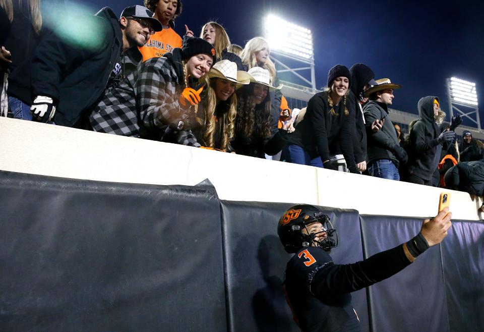 OSU quarterback Spencer Sanders takes a selfie with fans after leading the Cowboys to a 20-14 come-from-behind win over Iowa State on Saturday.