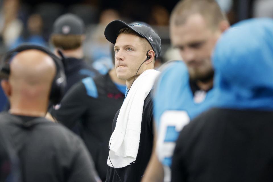 Carolina Panthers running back Christian McCaffrey watches play from the sideline against the Dallas Cowboys in the first half of a NFL football game in Arlington, Texas, Sunday, Oct. 3, 2021. (AP Photo/Michael Ainsworth)