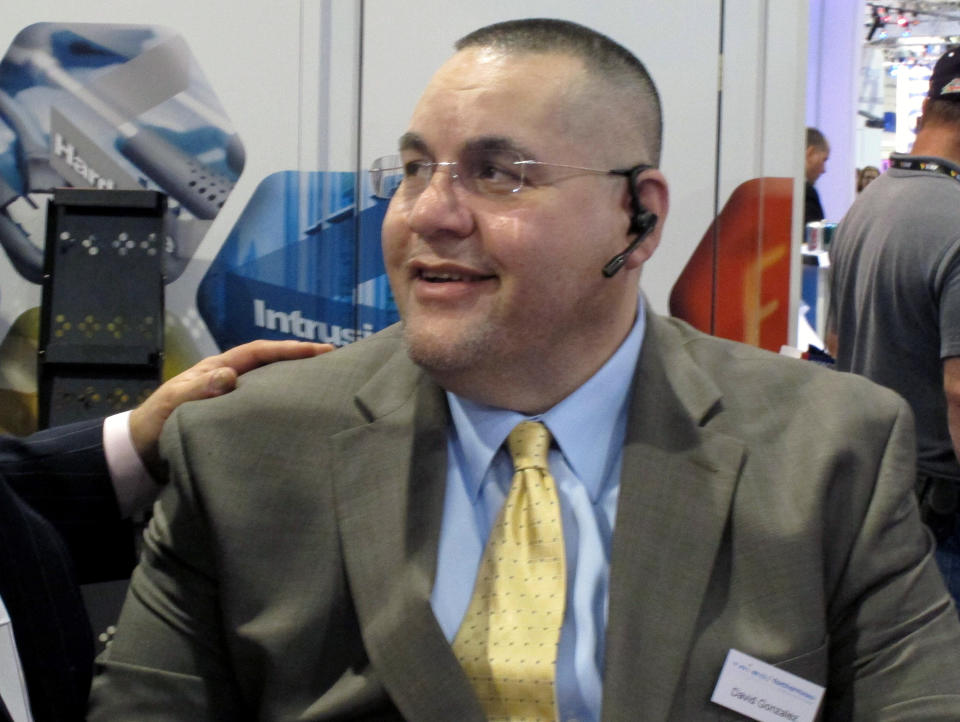 David Gonzalez, of Tannersville, Pa., is greeted by a colleague at the International Security Conference & Exposition in Las Vegas on Thursday, March 29, 2012. Gonzalez was a passenger aboard JetBlue flight 191 from New York to Las Vegas, credited with subduing the plane's captain after the captain went on a bizarre rant that forced an emergency landing in Amarillo, Texas. (AP Photo/Oskar Garcia)