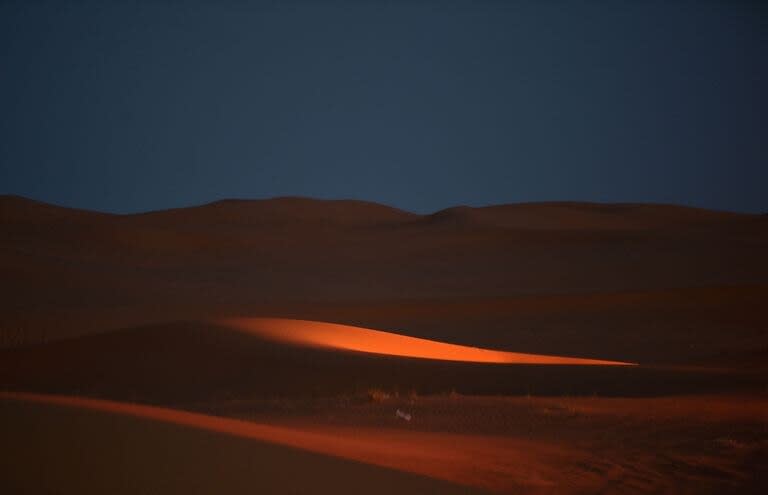 Vista del desierto donde un oasis artificial se ha levantado sobre dunas de color salmón, derrochando dinero tras un año de pandemia y en un momento en que el reino petrolero intenta impulsar el turismo nacional. (FAYEZ NURELDINE/FP)