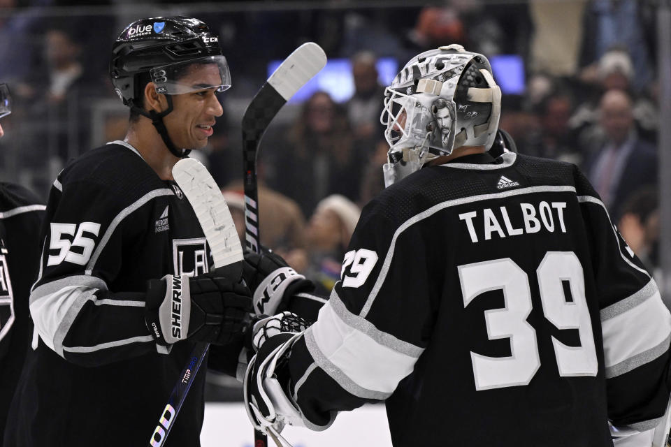 Los Angeles Kings right wing Quinton Byfield, left, celebrates with goaltender Cam Talbot after the Kings defeated the Calgary Flames in an NHL hockey game in Los Angeles, Saturday, Dec. 23, 2023. (AP Photo/Alex Gallardo)