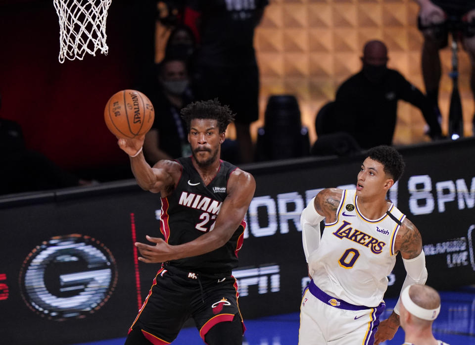 Miami Heat's Jimmy Butler (22) passes the ball against Los Angeles Lakers' Kyle Kuzma (0) during the first half in Game 3 of basketball's NBA Finals, Sunday, Oct. 4, 2020, in Lake Buena Vista, Fla. (AP Photo/Mark J. Terrill)