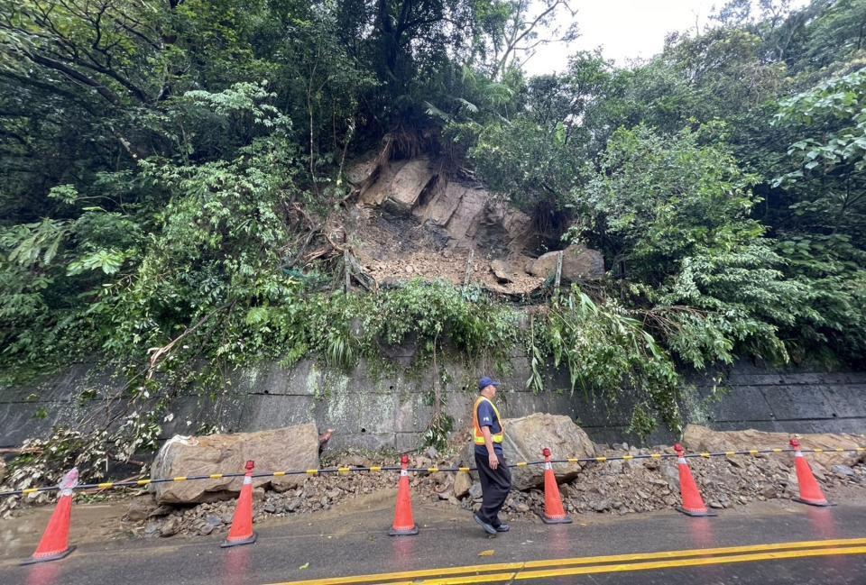 新北市8日晚間疑因持續降雨，導致山坡地土石鬆動，造成石碇區106乙線巨石崩落，警消獲報管制交通，經石碇區公所調派機具搶通為單線雙向通車，後續將調派大型機具清除。（圖／石碇區公所提供）