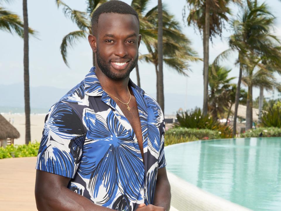 Aaron Bryant poses in white shorts and a blue printed shirt on "Bachelor in Paradise" season 9.