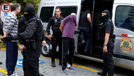 People detained during the probe known as "Operation Weak Flesh" are escorted by the police as they leave the Institute of Forensic Science in Curitiba, Brazil March 17, 2017. REUTERS/Rodolfo Buhrer