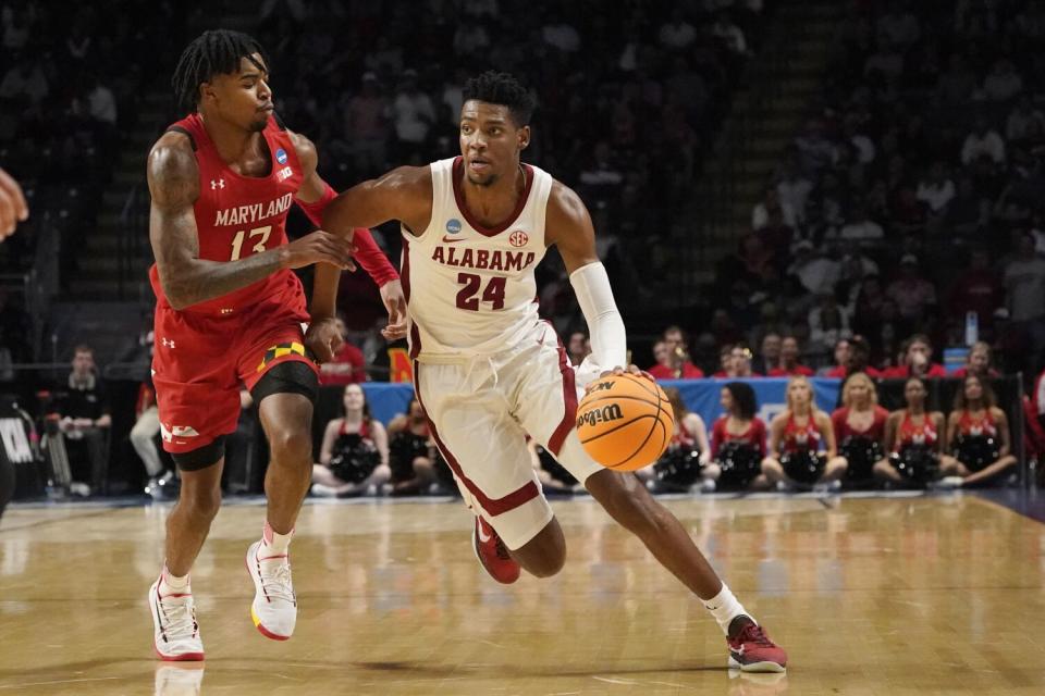 Alabama forward Brandon Miller controls the ball in front of Maryland guard Hakim Hart.