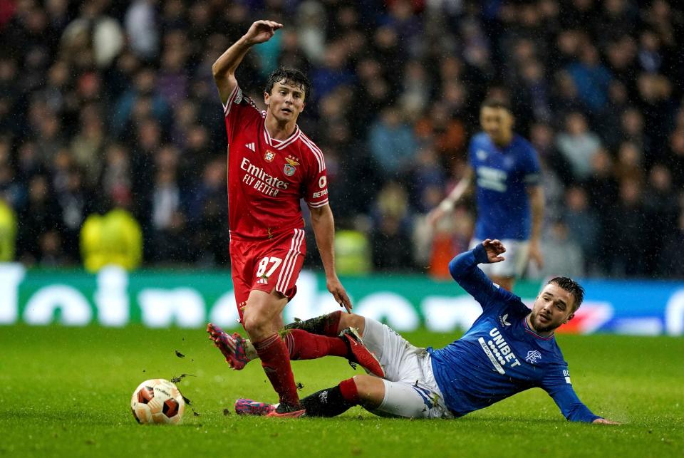 Benfica's João Neves, left, and Rangers' Nicolas Raskin challenge for the ball during the Europa League round of 16 second leg soccer match between Rangers FC and SL Benfica at the Ibrox Stadium, Glasgow, Scotland, Thursday, March 14, 2024. (Andrew Milligan/PA via AP)