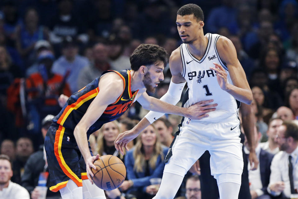 Oklahoma City forward Chet Holmgren, left, dribbles as San Antonio center Victor Wembanyama (1) defends during the first half of an NBA in-season tournament basketball game Tuesday, Nov. 14, 2023, in Oklahoma City. (AP Photo/Nate Billings)