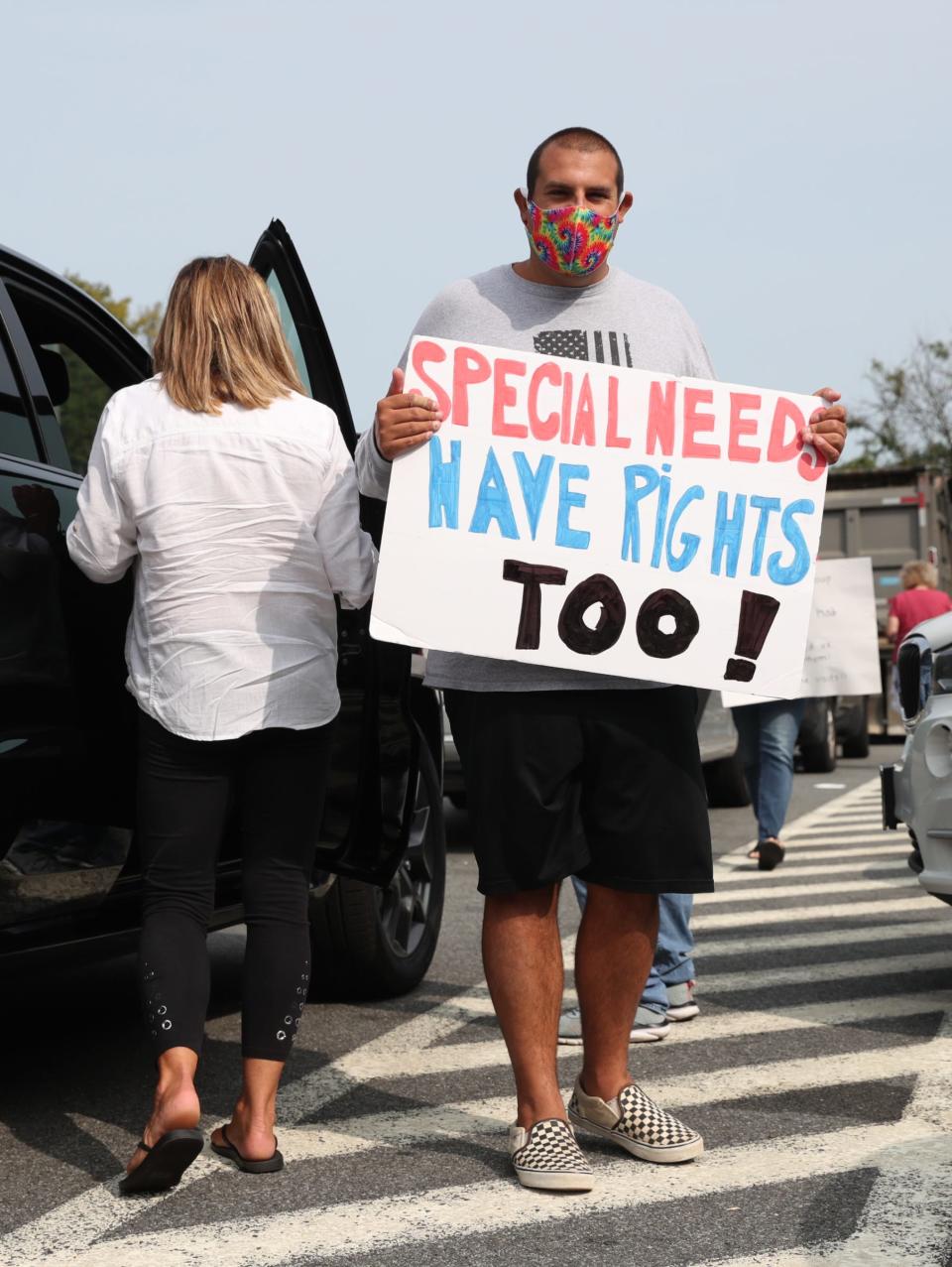Nicholas Bonasera, 27, from Amity Harbor holds a sign as families from around the state gather for a caravan at the NYS Thruway rest area in Ardsley on Thursday, September 17, 2020, to protest the fiscal shape of group homes which face further state aid cuts to their funding.