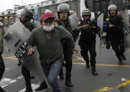 A riot police grabs hold of a supporter of former President Pedro Castillo outside the police station where Castillo arrived earlier, and where supporters had gathered and confronted riot police surrounding the station, in Lima, Peru, Wednesday, Dec. 7, 2022. Peru's Congress removed Castillo from office Wednesday, voting to replace him with the vice president, shortly after Castillo decreed the dissolution of the legislature ahead of a scheduled vote to oust him. (AP Photo/Martin Mejia)