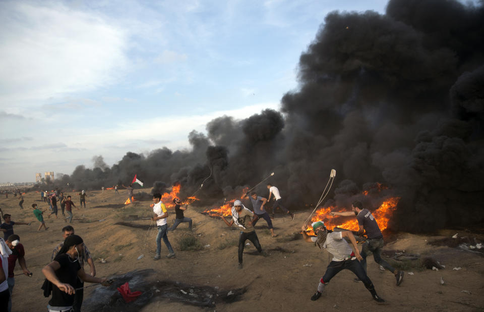 Palestinians hurl stones during a protest at the Gaza Strip's border with Israel, Friday, Oct. 5, 2018. (AP Photo/Khalil Hamra)