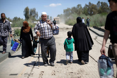 Iraqis walk along a pontoon bridge over the Tigris river on the outskirts of Hammam al-Alil, south of Mosul. REUTERS/Andres Martinez Casares