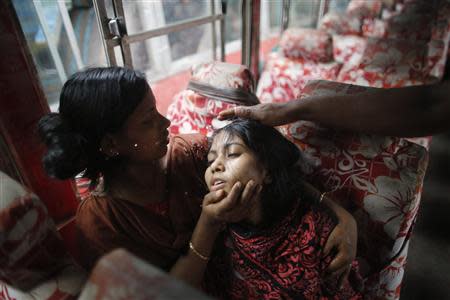 Colleagues comfort Mina, a garment worker, as she fell sick during a protest in Dhaka September 23, 2013. REUTERS/Andrew Biraj