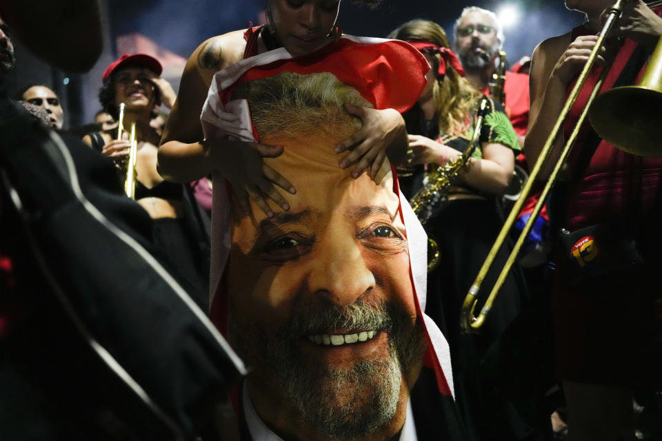 Un partidario del expresidente brasileño Luiz Inácio Lula da Silva sostiene una bandera con el rostro de Lula estampado después de que se anunciaran los resultados de la segunda vuelta de las elecciones presidenciales, el 30 de octubre de 2022, en Sao Paulo, Brasil. La autoridad electoral de Brasil dijo que Lula derrotó al titular Jair Bolsonaro para convertirse en el próximo presidente del país. (AP Foto/Matías Delacroix)