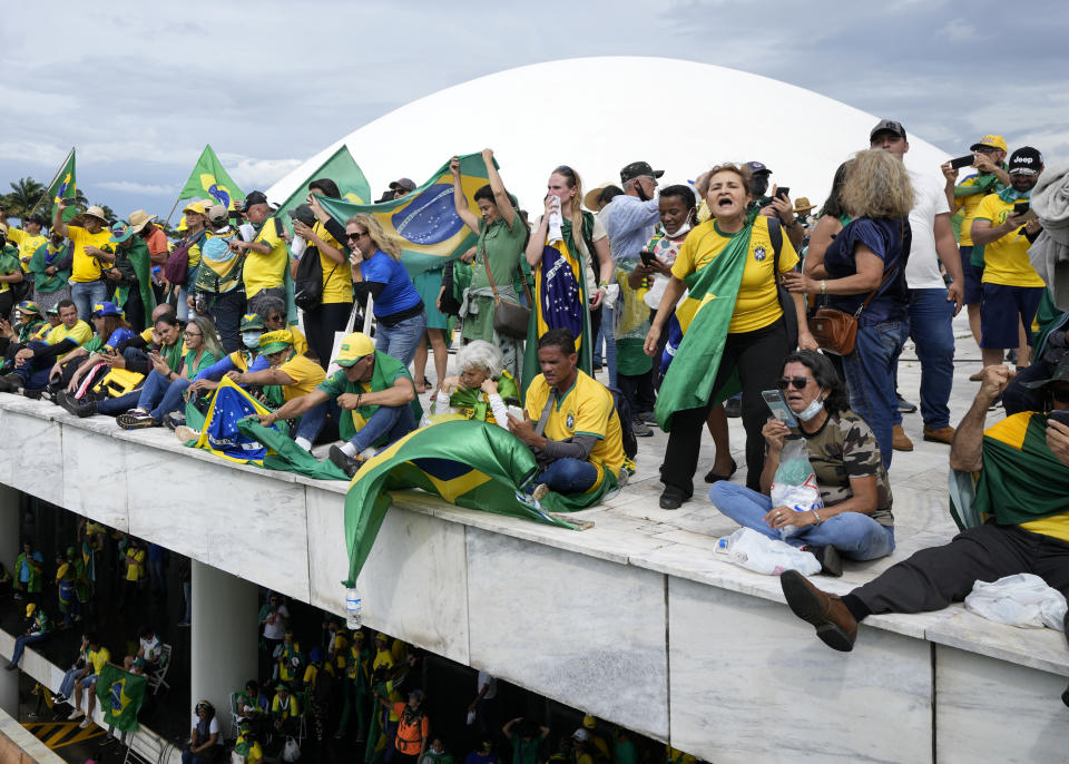 FILE - Protesters, supporters of Brazil's former President Jair Bolsonaro, stand on the roof of the National Congress building after they stormed it, in Brasilia, Brazil, Sunday, Jan. 8, 2023. (AP Photo/Eraldo Peres, File)