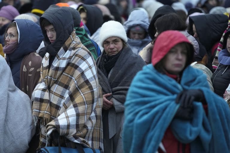 En esta imagen de archivo, refugiados, en su mayoría mujeres y niños, esperan junto a más gente para ser trasladados luego de llegar al paso fronterizo de Medyka, en Polonia, huyendo de la guerra en Ucrania, el 7 de marzo de 2022. (AP Foto/Markus Schreiber, archivo)