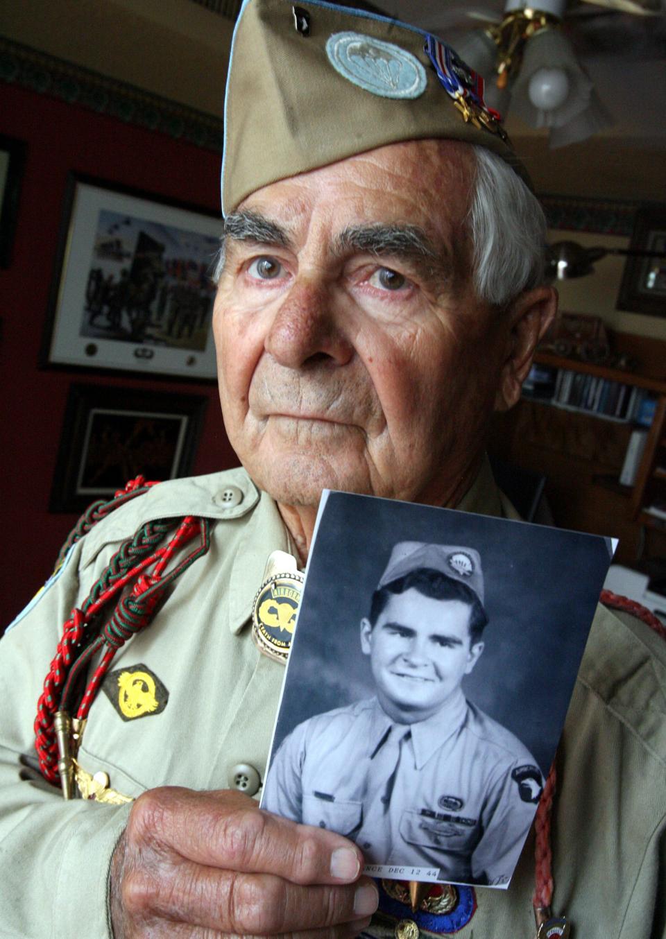 2009: Maynard Beamesderfer, 85, holds a picture of himself taken in 1944. He jumped behind German lines during the Allied invasion of Normandy.