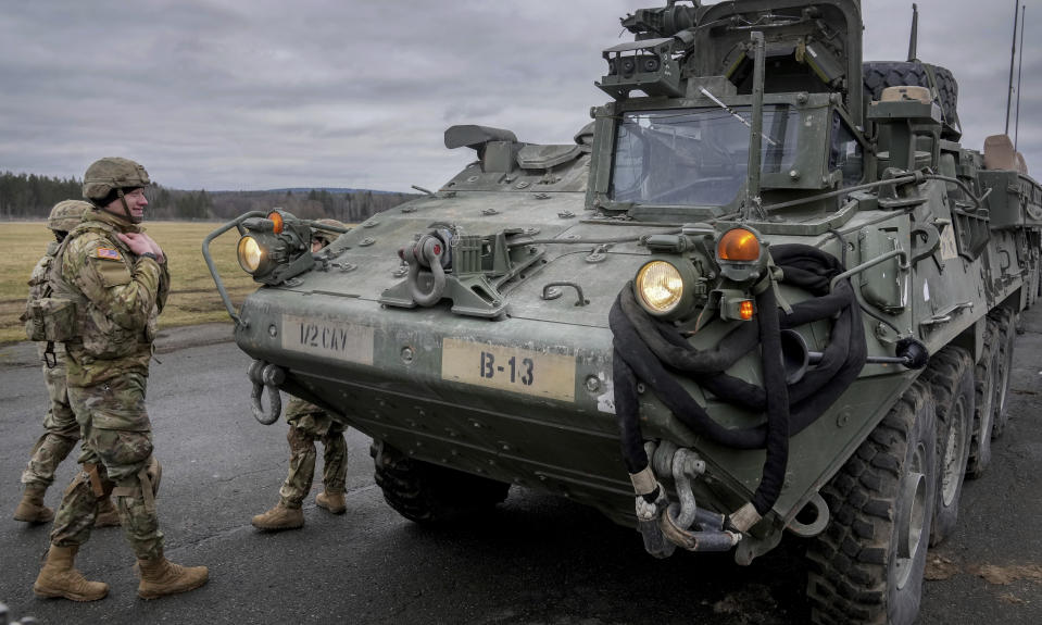FILE - Soldiers of the 2nd Cavalry Regiment stand next to a Stryker combat vehicle in Vilseck, Germany, Wednesday, Feb. 9, 2022. The U.S. is finalizing a massive package of military aid for Ukraine that U.S. officials say is likely to total as much as $2.6 billion. It's expected to include for the first time nearly 100 Stryker combat vehicles and at least 50 Bradley fighting vehicles to allow Ukrainian forces to move more quickly and security on the front lines. (AP Photo/Michael Probst, File)