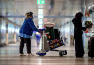 A woman wearing a face protection goes the parking lot at the airport in Frankfurt, Germany, Tuesday, March 30, 2021. (AP Photo/Michael Probst)