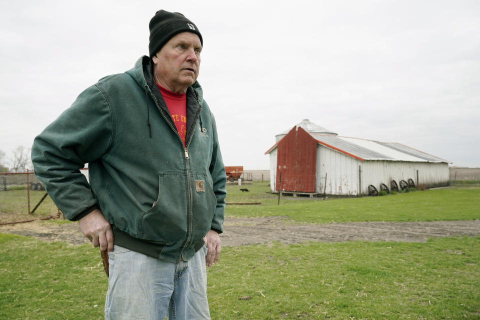 CORRECTS YEARS OF FARMING TO 43 INSTEAD OF 45 - Morey Hill stands near an outbuilding as he speaks about his farming operation, Friday, April 16, 2021, near Madrid, Iowa. In 43 years of farming, Hill had seen crop-destroying weather, rock-bottom prices, trade fights and surges in government aid, but not until last year had he endured it all in one season. Now, as Hill and other farmers begin planting the nation's dominant crops of corn and soybeans, they're dealing with another shift _ the strongest prices in years and a chance to put much of the recent stomach-churning uncertainty behind them. (AP Photo/Charlie Neibergall)