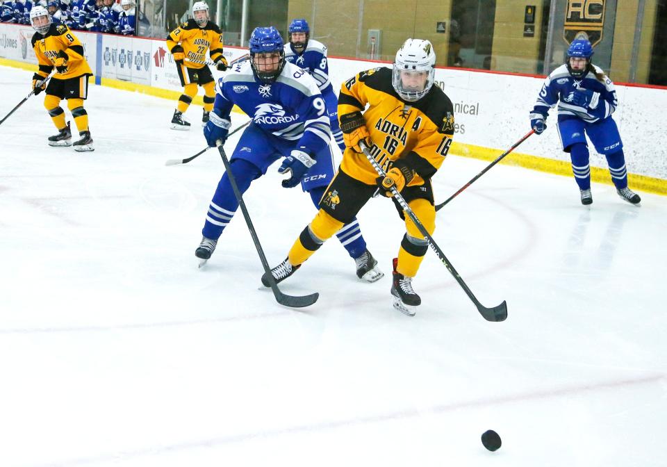 Une Bjelland of Adrian College chases the puck into the corner with Brooke Gibson of Concordia, Wisc., close behind Saturday night.