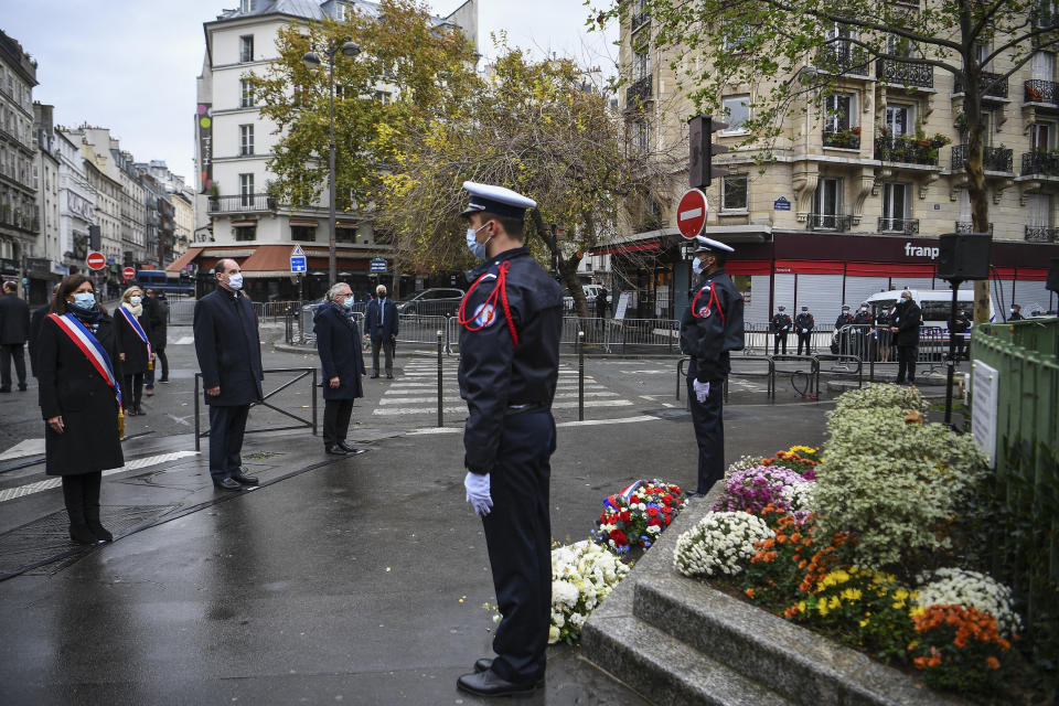 Paris Mayor Anne Hidalgo, left, and French Prime Minister Jean Castex, 2nd left, participate in a wreath laying ceremony, marking the 5th anniversary of the Nov. 13, 2015 attacks outside the Bonne Biere cafe bar in Paris, Friday, Nov. 13, 2020. In silence and mourning, France is marking five years since 130 people were killed by Islamic State extremists who targeted the Bataclan concert hall, Paris cafes and the national stadium. (Christophe Archambault/Pool Photo via AP)