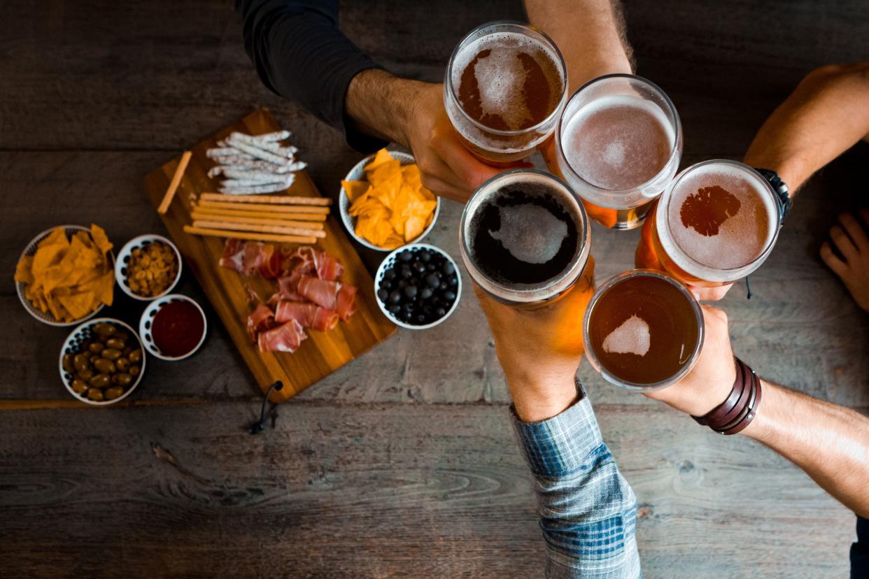 Friends toasting beers at happy hour