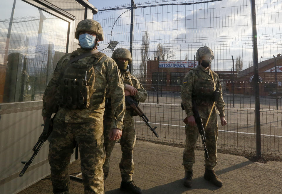 Ukrainian soldiers guard a check point at the town Shshastya, Ukraine, near Luhansk, Ukraine, Friday, April 16, 2021. Growing cease-fire violations and a massive Russian military buildup near the Ukrainian border are causing tensions to rise in the conflict in eastern Ukraine, where more than 14,000 people have died in seven years of fighting between forces from Kyiv and separatists loyal to Moscow.(AP Photo/Efrem Lukatsky)