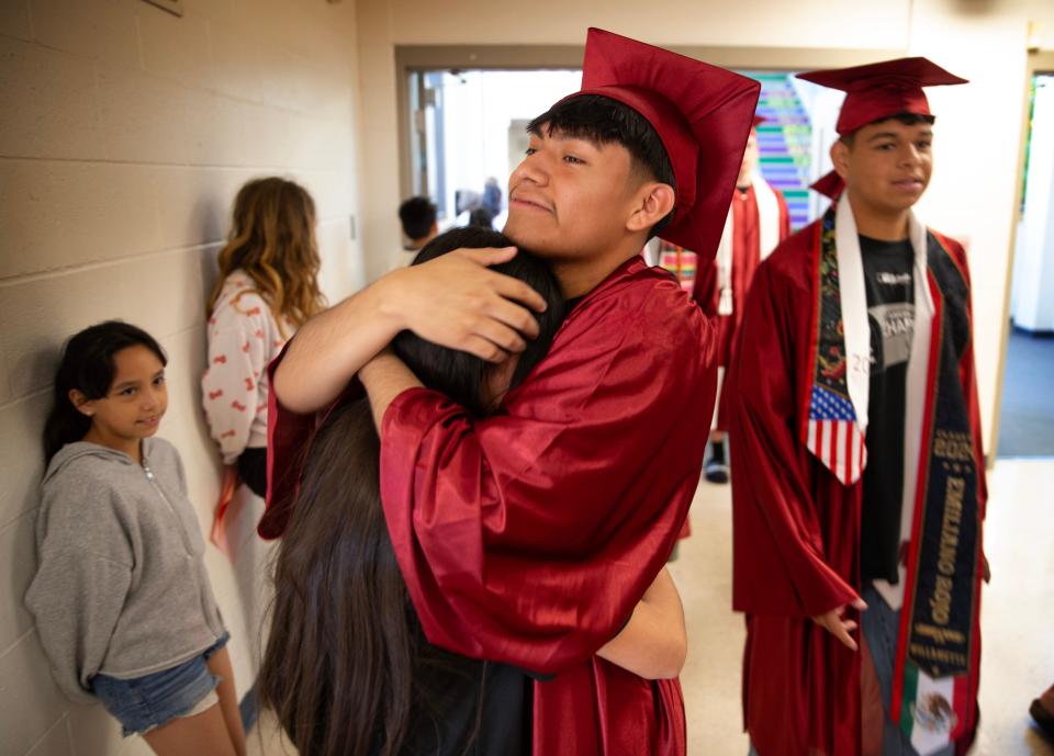 Willamette High School graduate Juan Padilla, center, gives his sister Lupita Padilla, 10, a hug as he and other graduates celebrate their achievement with Prairie Mountain School students on June 6.