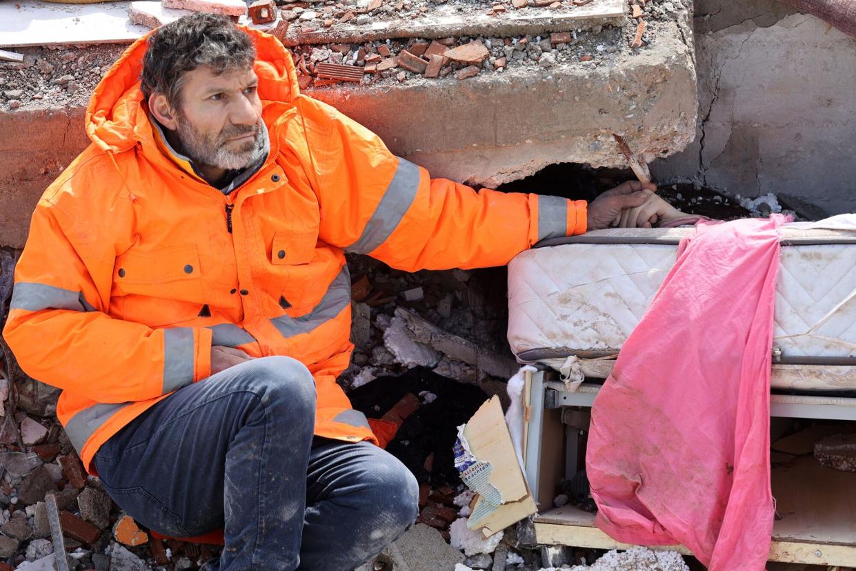 Mesut Hancer holds the hand of his 15-year-old daughter Irmak, who died in the earthquake in Kahramanmaras, close to the quake's epicentre, the day after a 7.8-magnitude earthquake struck the country's southeast, on February 7, 2023. - Rescuers in Turkey and Syria braved frigid weather, aftershocks and collapsing buildings, as they dug for survivors buried by an earthquake that killed more than 5,000 people. Some of the heaviest devastation occurred near the quake's epicentre between Kahramanmaras and Gaziantep, a city of two million where entire blocks now lie in ruins under gathering snow.