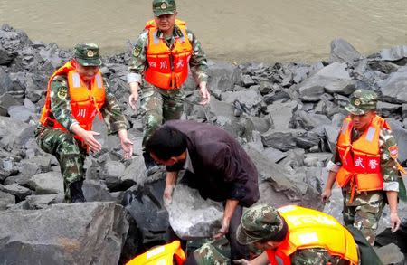 Rescue personnel work at the site of a landslide that destroyed some 40 households, where more than 100 people are feared to be buried, according to local media reports, in Xinmo Village, China June 24, 2017. REUTERS/Stringer