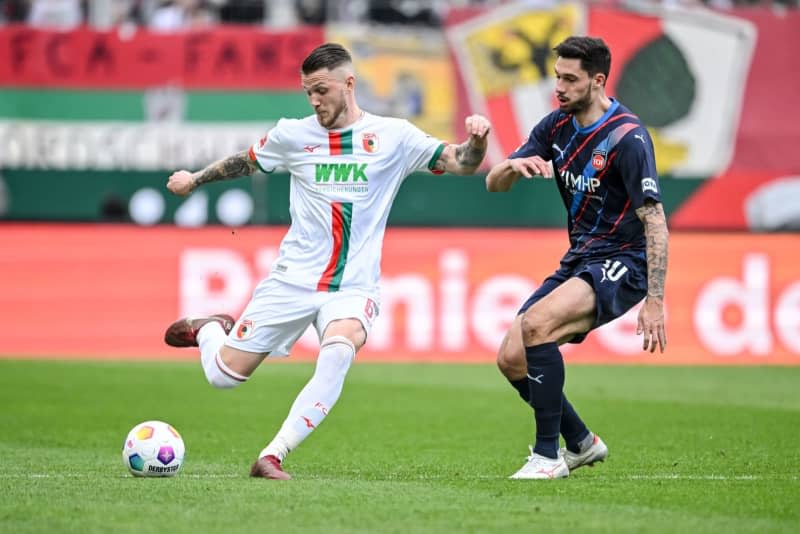 Augsburg's Jeffrey Gouweleeuw (L) and Heidenheim's Tim Kleindienst battle for the ball during the German Bundesliga soccer match between FC Augsburg and 1. FC Heidenheim at WWK Arena. Harry Langer/dpa