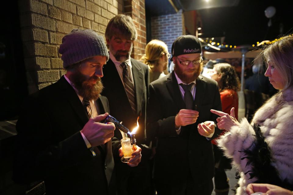 FILE - In this Dec. 31, 2013 file photo, partygoers smoke marijuana during a Prohibition-era themed New Year's Eve invite-only party celebrating the start of retail pot sales, at a bar in Denver. Colorado is on the brink of becoming the first state with licensed pot clubs. Denver officials are working on regulations to open a one-year pilot of bring-your-own marijuana clubs. (AP Photo/Brennan Linsley, file)